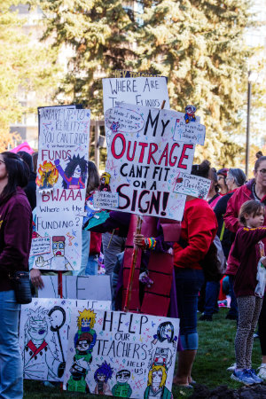 A group of protesting teachers holding signs.
