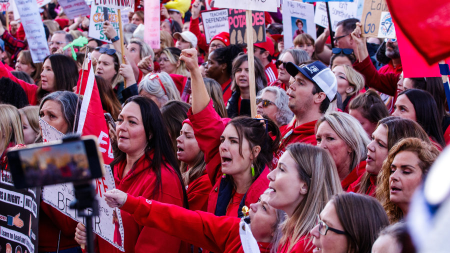 A close up of teachers on strike carrying picket signs